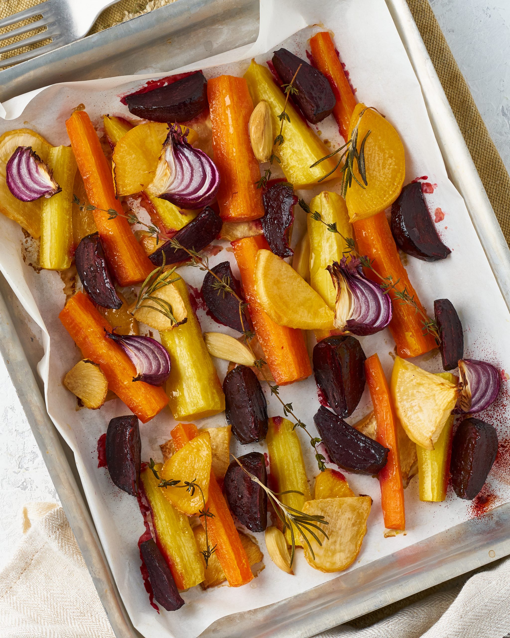 colorful roasted root vegetables on tray with parchment